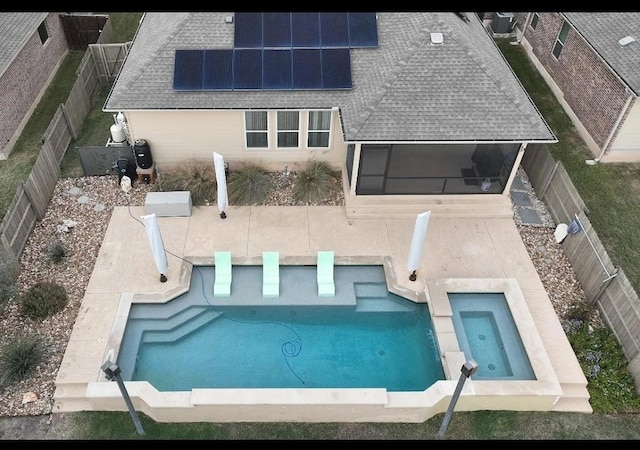 525 Scenic Bluff Dr, Georgetown, TX 78628 - rear view of house featuring a sunroom, roof with shingles, a fenced in pool, and solar panels