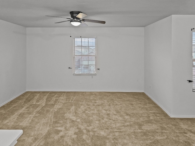 spare room with light colored carpet, ceiling fan, and a textured ceiling