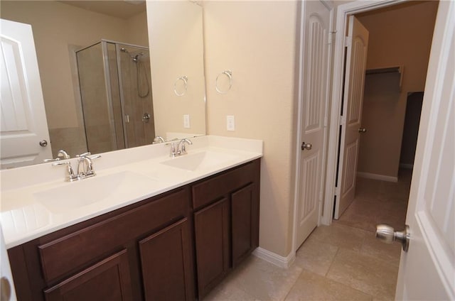 409 Epiphany Ln, Pflugerville, TX 78660 - bathroom with a stall shower, double vanity, a closet, tile patterned floors, and baseboards