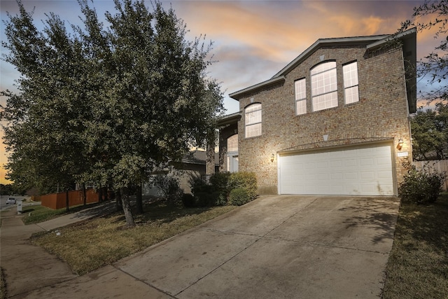 view of front of property with an attached garage, driveway, and brick siding