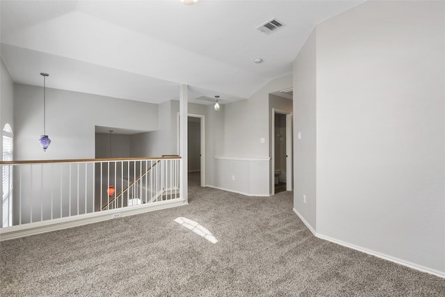 unfurnished room with lofted ceiling, carpet floors, visible vents, and baseboards