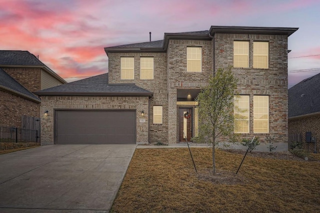 traditional-style home featuring driveway, a shingled roof, and an attached garage