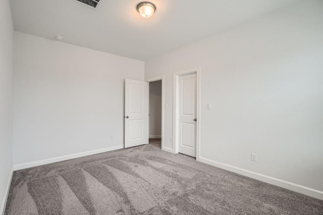 empty room featuring baseboards and carpet flooring