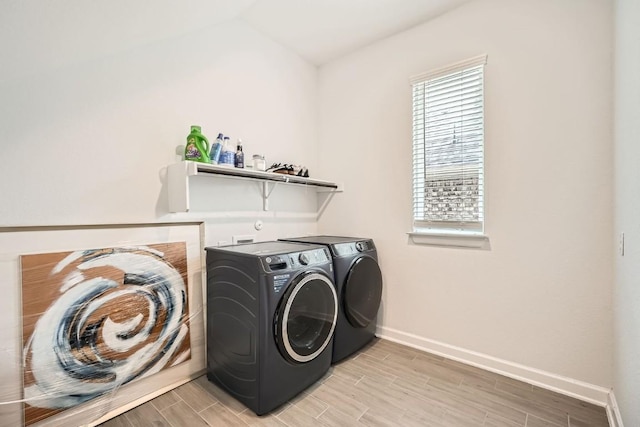 washroom featuring laundry area, wood tiled floor, a wealth of natural light, and washing machine and clothes dryer