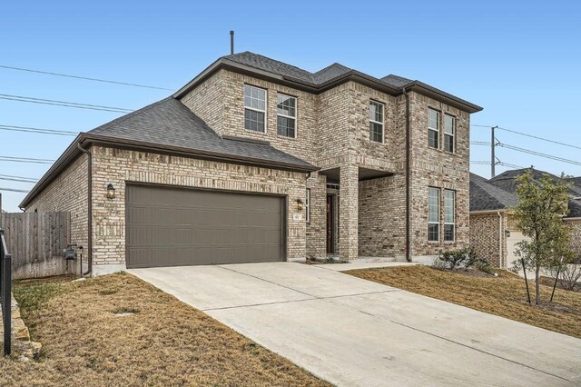 582 Wild Pecan Loop, Buda, TX 78610 - view of front facade with concrete driveway, brick siding, and roof with shingles