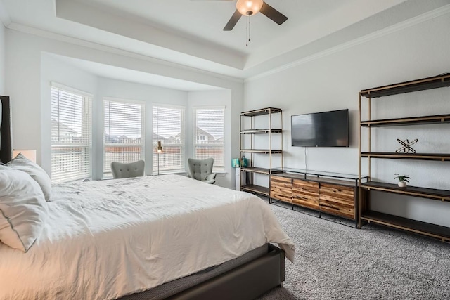 bedroom featuring a tray ceiling, carpet flooring, crown molding, and ceiling fan