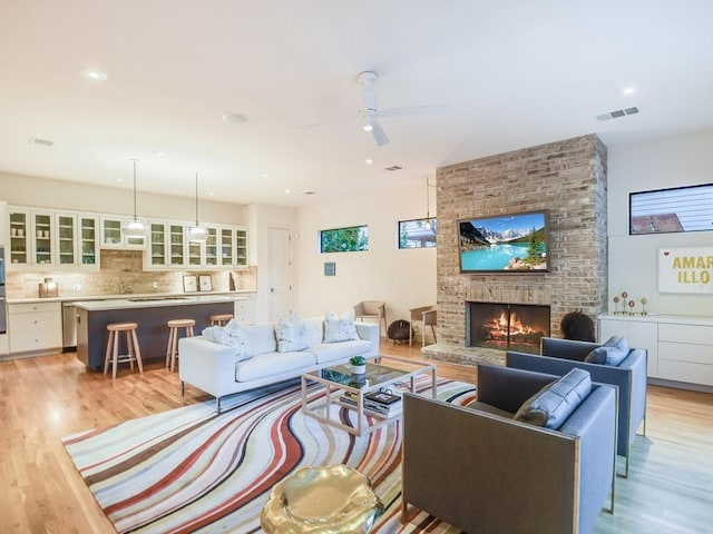 2312 W 8th St, Austin, TX 78703 - living room featuring a ceiling fan, light wood-type flooring, a fireplace, and recessed lighting