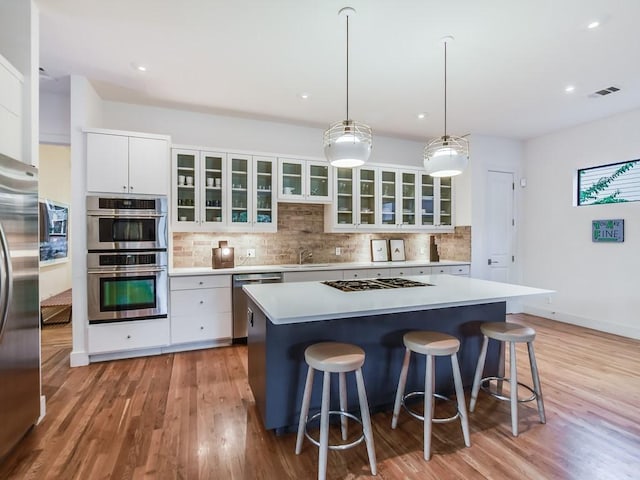 2312 W 8th St, Austin, TX 78703 - kitchen featuring appliances with stainless steel finishes, decorative backsplash, a kitchen breakfast bar, and recessed lighting