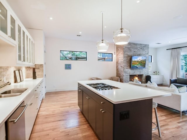 2312 W 8th St, Austin, TX 78703 - kitchen with stainless steel appliances, a breakfast bar area, a kitchen island, light countertops, and white cabinetry