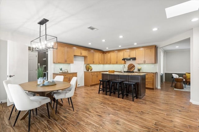 dining room featuring a skylight, visible vents, wood finished floors, and recessed lighting