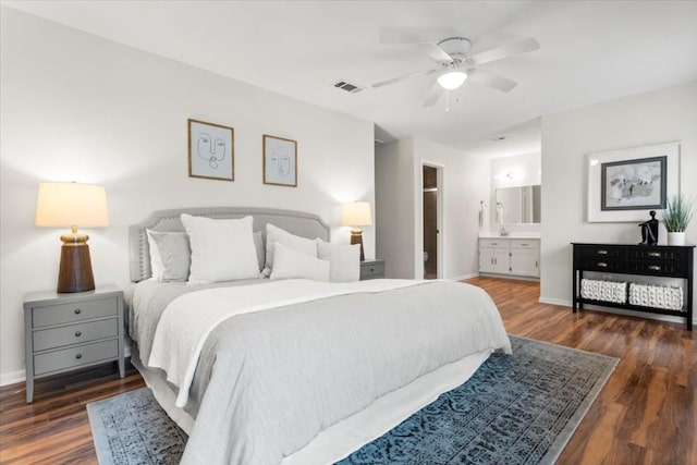 bedroom featuring dark wood-style flooring, visible vents, ensuite bath, and baseboards