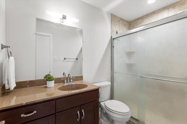 full bath with toilet, a stall shower, and vanity