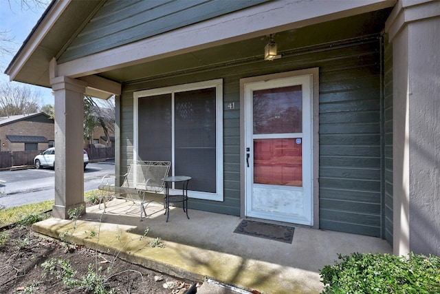 view of exterior entry featuring covered porch