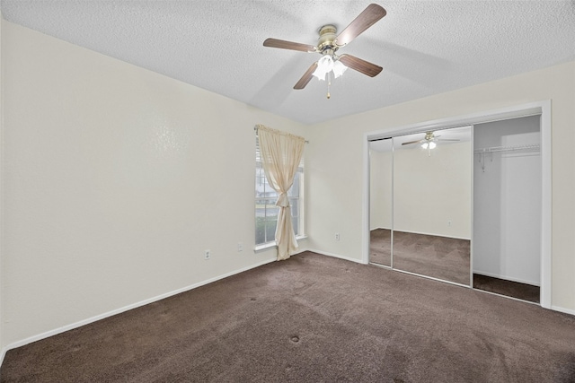 unfurnished bedroom with a textured ceiling, ceiling fan, a closet, and dark carpet