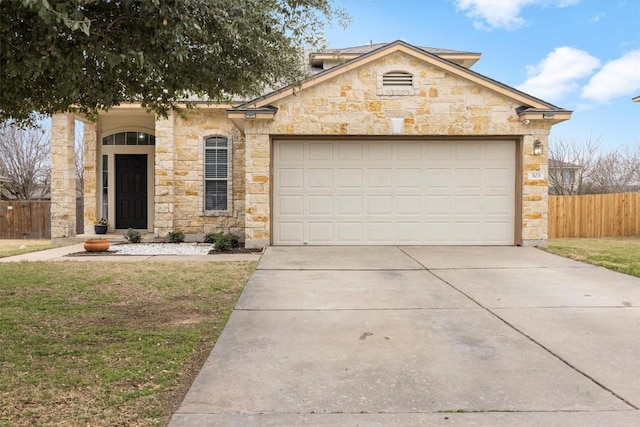 view of front of house with a garage, stone siding, driveway, and fence