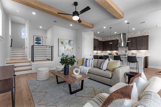 11 Doverland Dr, Lakeway, TX 78738 - living area featuring light wood finished floors, beamed ceiling, a ceiling fan, recessed lighting, and stairs