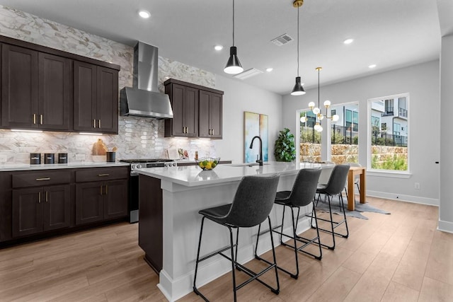 11 Doverland Dr, Lakeway, TX 78738 - kitchen featuring wall chimney range hood, stainless steel range with electric stovetop, a sink, light countertops, and backsplash