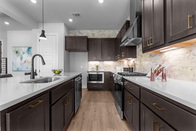 11 Doverland Dr, Lakeway, TX 78738 - kitchen with appliances with stainless steel finishes, a sink, light wood-type flooring, dark brown cabinetry, and light countertops