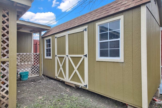 view of shed featuring fence