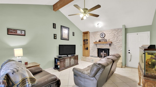 living room with ceiling fan, a stone fireplace, beamed ceiling, and light tile patterned flooring