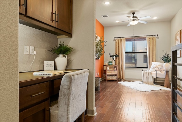 home office featuring dark wood finished floors, recessed lighting, visible vents, built in study area, and ceiling fan