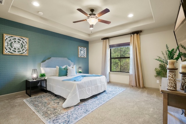 bedroom with carpet floors, wallpapered walls, baseboards, and a raised ceiling