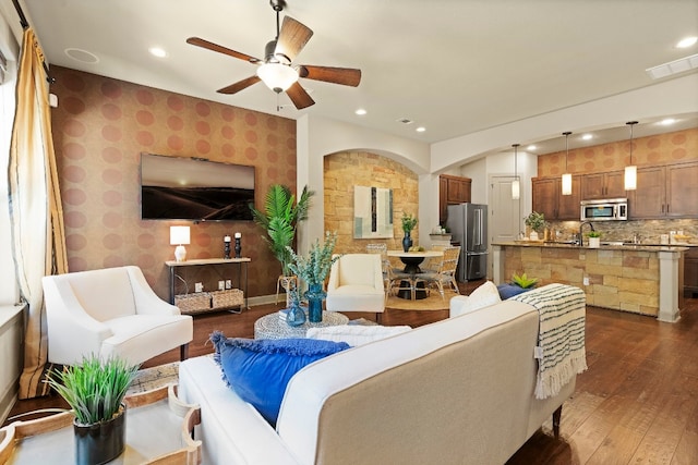 living room with dark wood-style floors, recessed lighting, visible vents, and wallpapered walls