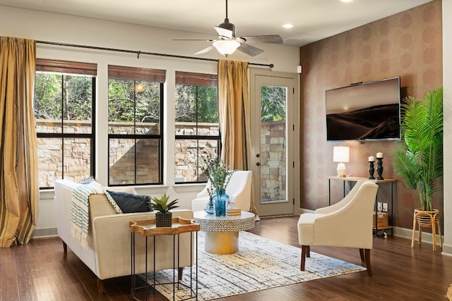 sitting room featuring dark wood-style floors, ceiling fan, baseboards, and a wealth of natural light