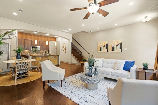 living area with dark wood-type flooring, recessed lighting, stairway, and a ceiling fan