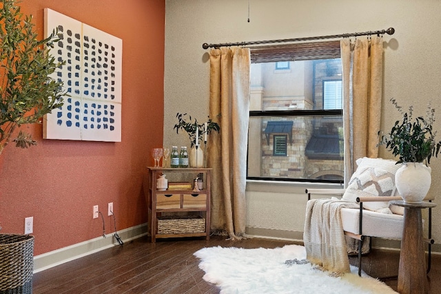 sitting room with dark wood finished floors and baseboards