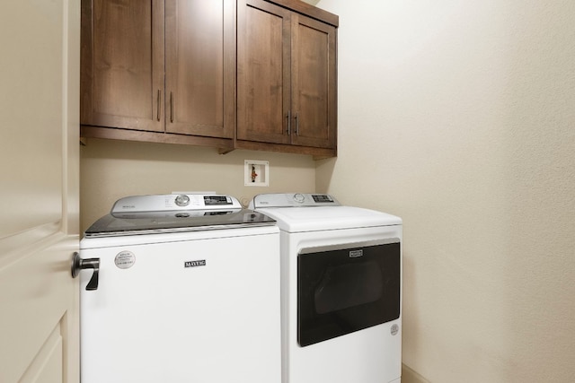 laundry area featuring washing machine and clothes dryer and cabinet space