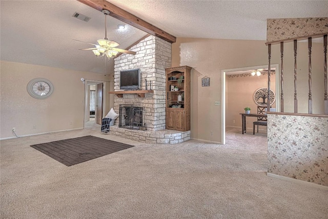unfurnished living room with visible vents, a ceiling fan, a textured ceiling, a stone fireplace, and beam ceiling