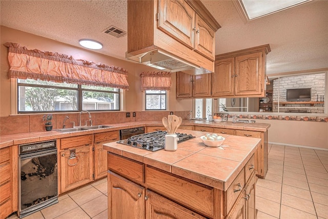 kitchen with visible vents, a sink, tile countertops, and light tile patterned flooring