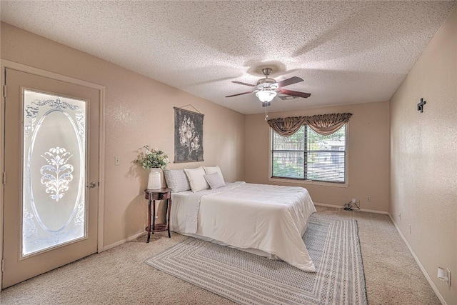 bedroom featuring baseboards, a ceiling fan, a textured wall, carpet flooring, and a textured ceiling
