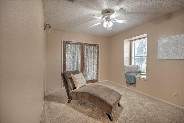 living area with light carpet, a textured ceiling, and a textured wall