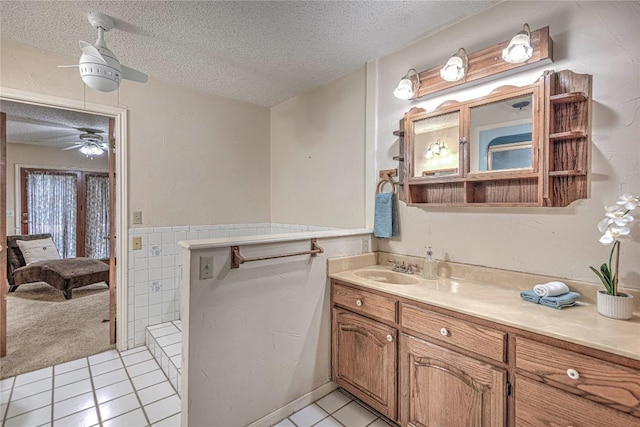 bathroom featuring a textured ceiling, a wainscoted wall, vanity, and tile patterned floors