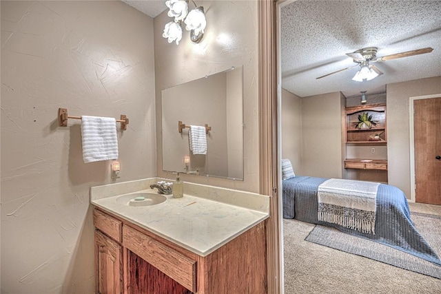 ensuite bathroom with a textured ceiling, connected bathroom, vanity, and a ceiling fan
