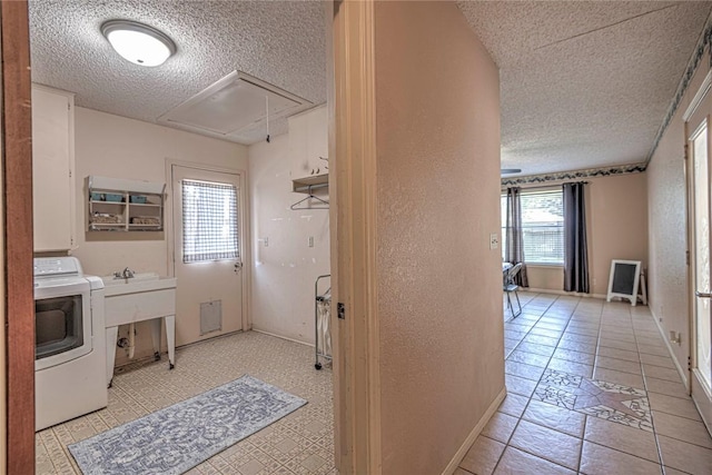 laundry area with a textured wall, attic access, a textured ceiling, washer / dryer, and laundry area