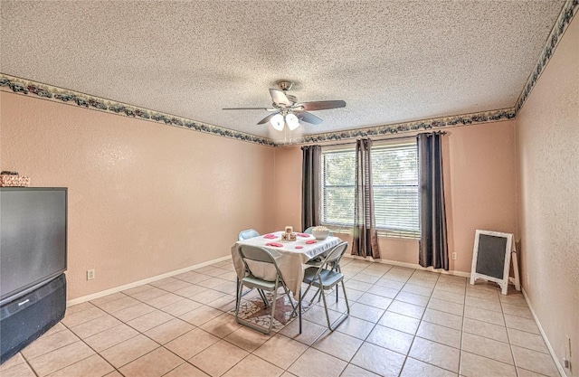 dining space with baseboards, a ceiling fan, a textured wall, a textured ceiling, and light tile patterned flooring