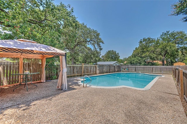 view of pool featuring a patio area, a fenced backyard, a fenced in pool, and a gazebo