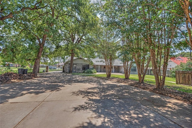 view of front facade with driveway and fence
