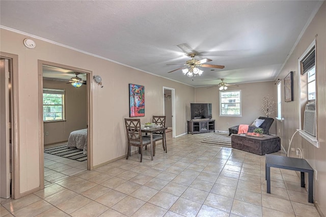 living room featuring light tile patterned floors, baseboards, and crown molding