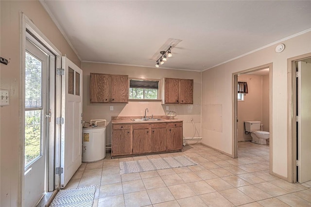 kitchen with brown cabinets, light countertops, a sink, and ornamental molding