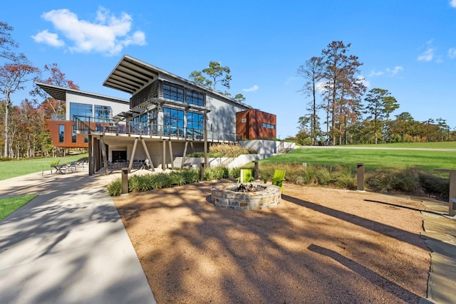 view of front of house with an outdoor fire pit, a front lawn, and a patio area