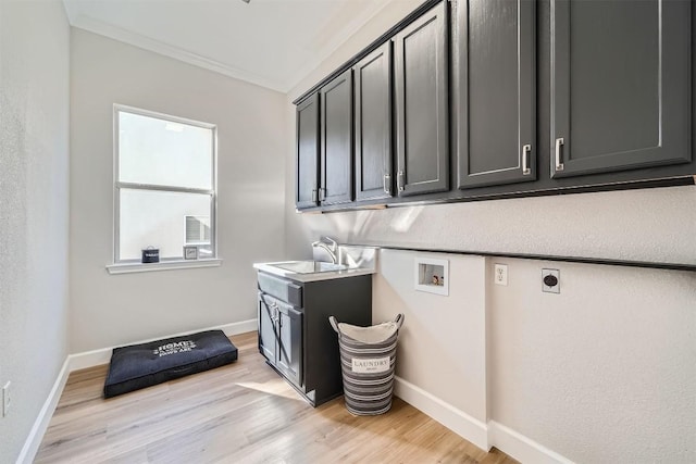 102 Blue Sky Ct, Georgetown, TX 78633 - laundry area featuring cabinet space, hookup for a washing machine, hookup for an electric dryer, ornamental molding, and light wood-style floors
