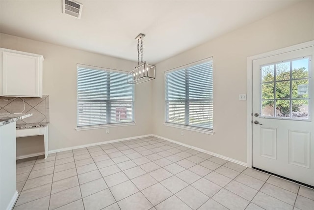1003 Preserve Pl, Round Rock, TX 78665 - unfurnished dining area featuring plenty of natural light, a chandelier, baseboards, and light tile patterned floors