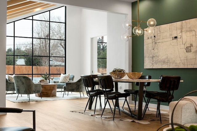 dining space featuring a high ceiling, wood finished floors, and a wealth of natural light