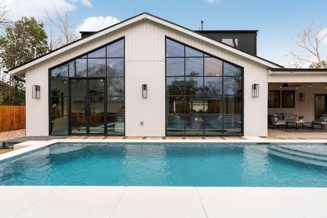 outdoor pool featuring a patio area, fence, and an outdoor hangout area