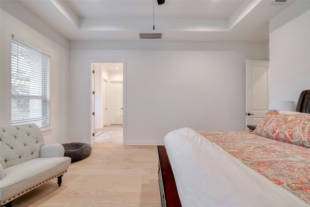 521 Wonderstruck, Liberty Hill, TX 78642 - bedroom featuring a raised ceiling, light wood-style floors, and a ceiling fan