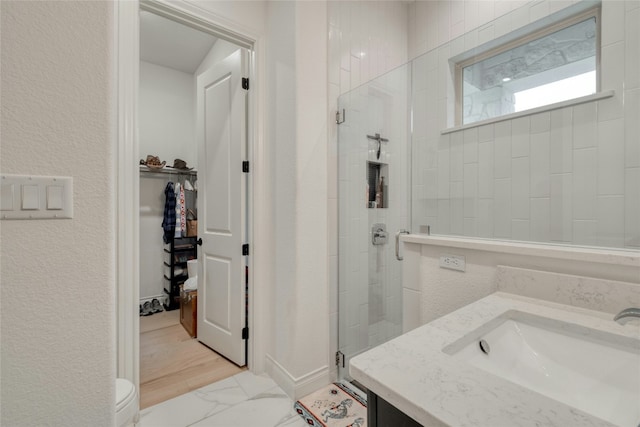 521 Wonderstruck, Liberty Hill, TX 78642 - full bath featuring a shower stall, a spacious closet, vanity, and a textured wall